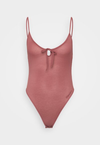 Ribbed one-piece swimsuit in dusty rose with adjustable straps, front tie detail, and high-cut legs. Subtle branding on the side.