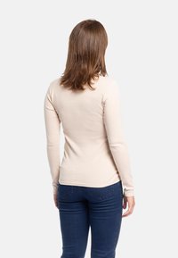 Top a maniche lunghe, aderente, in misto cotone beige, con scollo rotondo, texture liscia e dettagli di cucitura sottili sull'orlo.