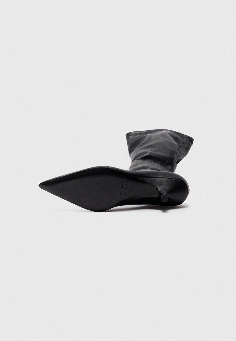 Schwarze, spitze Knöchelstiefel aus glattem Leder. Verfügt über einen schlanken, hohen Absatz und ein weiches, gerafftes Obermaterial. Die Sohle weist Markendetails auf.