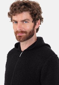 Schwarze Fleecejacke mit Kapuze und Reißverschluss vorne, mit einer strukturierten, leicht flauschigen Oberfläche. Keine Grafiken oder Muster sichtbar.