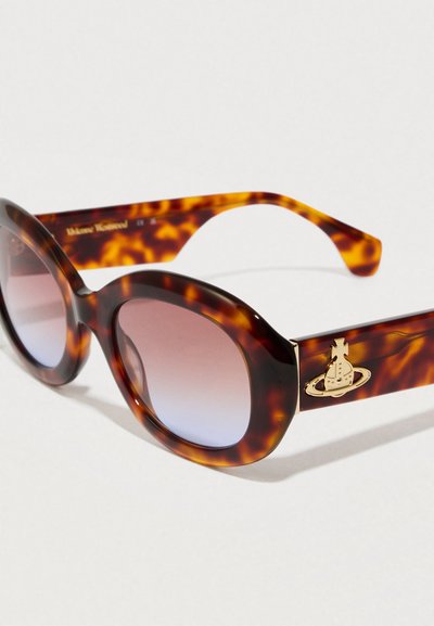 Τετράγωνα γυαλιά ηλίου με �καφέ-κίτρινο μοτίβο, υπερμεγέθεις οβάλ φακοί, gradient μωβ απόχρωση και χρυσό πλανήτη σε φιλέτα. Υφασμάτινος πλαστικός σκελετός.