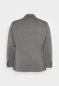 Grå kavaj med tvåknapplikning, kammade slag och enkel slits. Texturerad tyg och tre dekorativa knappar på varje ärm.