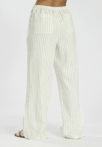 Pantalones fluidos, ligeros y a rayas en color blanco roto con rayas marinas. Cuentan con una cintura elástica y dos bolsillos traseros.