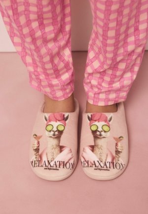 Feet in pink checkered pajama pants wearing slippers with a llama in a towel, cucumber slices on eyes, holding a cocktail. Text: "RELAXATION."