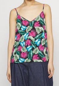 Camisola con stampa floreale caratterizzata da una profonda scollatura a V, spalline sottili e uno sfondo nero con vivaci foglie tropicali rosa e blu.