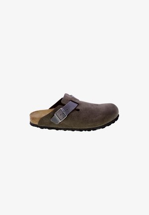 Sabot en daim marron avec un bout rond, sangle ajustable avec une boucle métallique et une semelle en caoutchouc noir texturé.