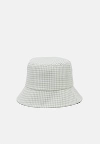 Zaļi un balti pārklāts kausa cepure, izgatavota no mīksta auduma, ar plašu malu un noapaļotu kroni.