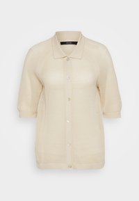 Strikkegenser i lys beige, med kragehals, korte ermer, knappelukking og teksturert stoff med pustende åpen veving.