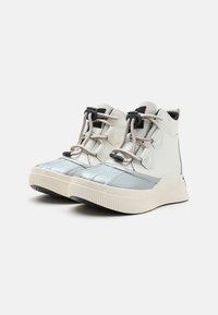 Zapatillas altas en blanco y plata. Las características del material incluyen cuero liso y tejido texturizado. Suela de goma redondeada con un diseño patroneado.