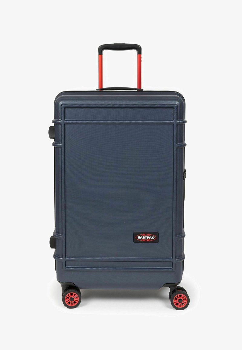 Tvrdý kufr tmavě námořnické modři s červenými akcenty. Obsahuje teleskopickou rukojeť, čtyři multi-směrová kolečka a boční rukojeť.