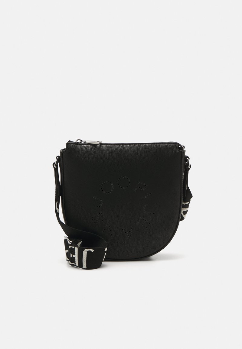 Črna zaobljena crossbody torba izdelana iz teksturiranega materiala, ki vsebuje zadrgo in trak s kontrastnim belim napisom.