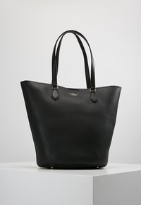 Zwarte leren tote bag met een gestructureerde afwerking, brede opening en twee schouderriemen. Gouden accenten aan de basis versterken het ontwerp.