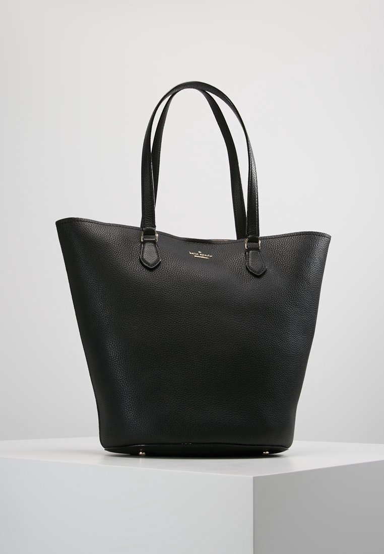 Zwarte leren tote bag met een gestructureerde afwerking, brede opening en twee schouderriemen. Gouden accenten aan de basis versterken het ontwerp.