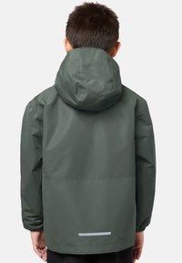 Grön vattentät jacka med huva, elastiska manschetter och reflektiv rem på ryggen. Slät textur, lös passform designad för komfort.