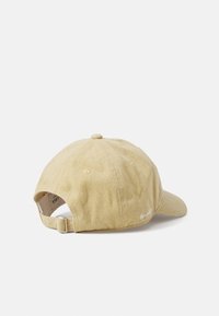 Gorra de béisbol caqui con visera curvada, correa ajustable y detalles bordados, hecha de tejido de algodón texturizado.
