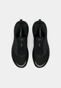 Ζευγάρι μαύρων Adidas Supernova αθλητικών παπουτσιών, ορατό από πάνω με φόντο λευκό, που δείχνει τα κορδόνια και τις θηλιές.