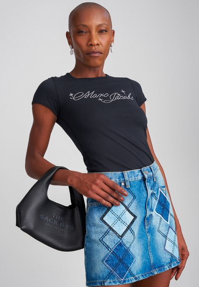 Μαύρη εφαρμοστή μπλούζα με ασημί κέντημα "Marc Jacobs". Μπλε τζιν φούστα με διαμαντένια σχέδια. Μαύρη δερμάτινη τσάντα με το κείμενο "THE SACK BAG".