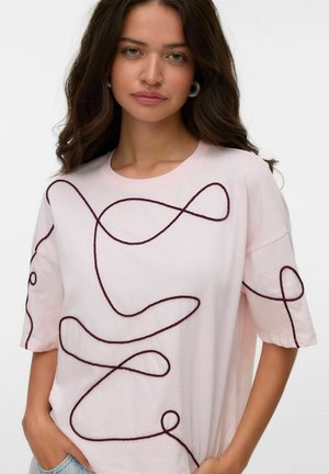 T-shirt en coton rose clair avec broderie abstraite en lignes bourgogne foncé. Manches courtes et design col rond.