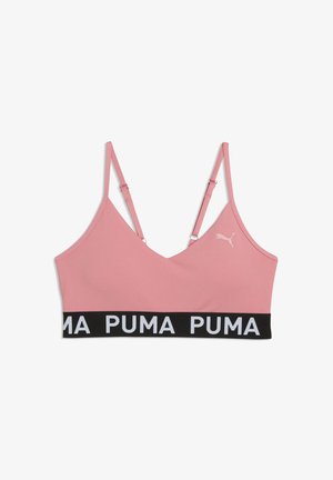 Reggiseno sportivo rosa con spalline regolabili, fascia elastica nera con testo "PUMA" ripetuto e piccolo logo Puma sul lato sinistro.