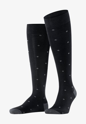 Knielange schwarze Socken mit weicher Textur, verziert mit grauen Punkten sowie grauen Akzenten an Zehen und Ferse. Gerippter Saum für zusätzlichen Halt.