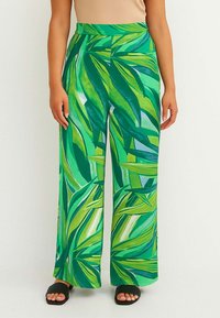 Pantaloni larghi verdi con un vivace motivo a foglie, realizzati in materiale leggero, con vita alta e una texture morbida.