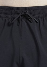 Sorte badebukser med elastisk linning og snorlukning. Stoffet er glatt og lett, uten synlige mønstre eller detaljer.