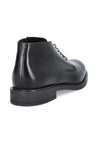 Czarne skórzane botki za kostkę o gładkiej fakturze, z zaokrąglonym noskiem i płaską podeszwą. Posiadają sznurowanie i minimalne detale stębnowania po boku.