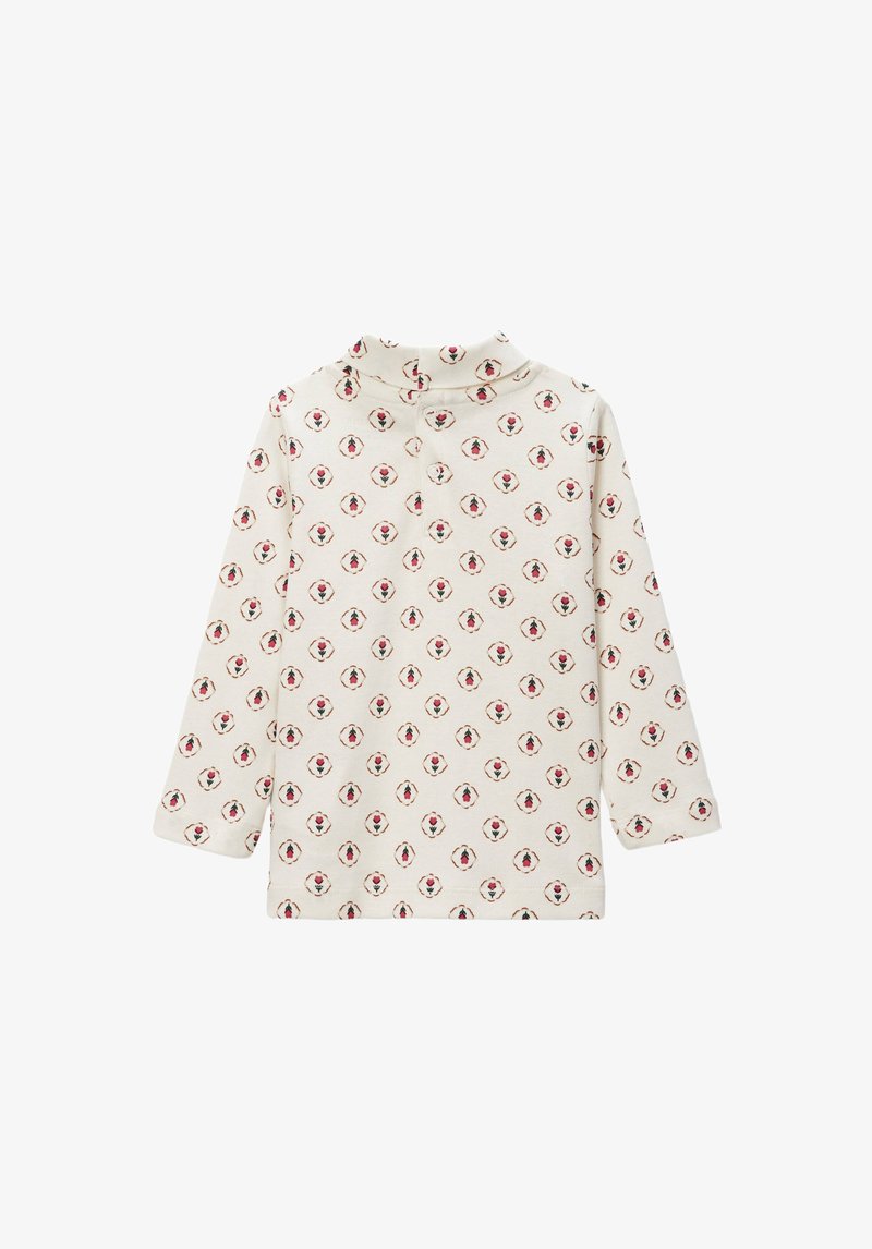 Haut en coton à manches longues couleur crème avec un motif floral répété en rouge et vert. Comprend un col montant et une fermeture à bouton au col.