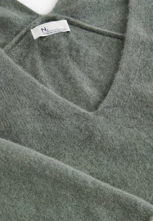 Roheline villane sviiter sügava V-kaelusega, millel on pehme tekstuur ja silt "N. PREMIUM COLLECTION." Nurga alt vaadet näitab kaeluse detail.