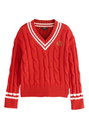 Rød kabelstrikket V-hals sweater med hvide striber på kraven og manchetter samt et lille broderet våbenskjold på brystet.