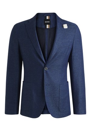 Navy blue blazer made of textured fabric with a single button closure, two front pockets, and a white flower pin accent.