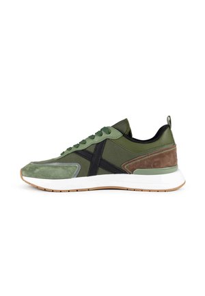Lage sneaker in groen mesh en suède met zwarte accenten, bruine hielstukken, witte zool en rubberen buitenzool, zijaanzicht.
