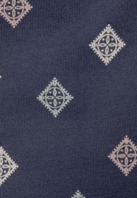 Tessuto blu navy con una finitura testurizzata, caratterizzato da un motivo a diamante ripetuto in rosa pallido e verde menta, contornato da dettagli fini.