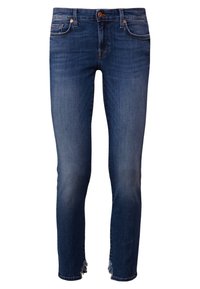 Mörkblå denimjeans med en åtsittande passform, med rå fåll vid anklarna och kopparfärgade detaljer på midjebandet.