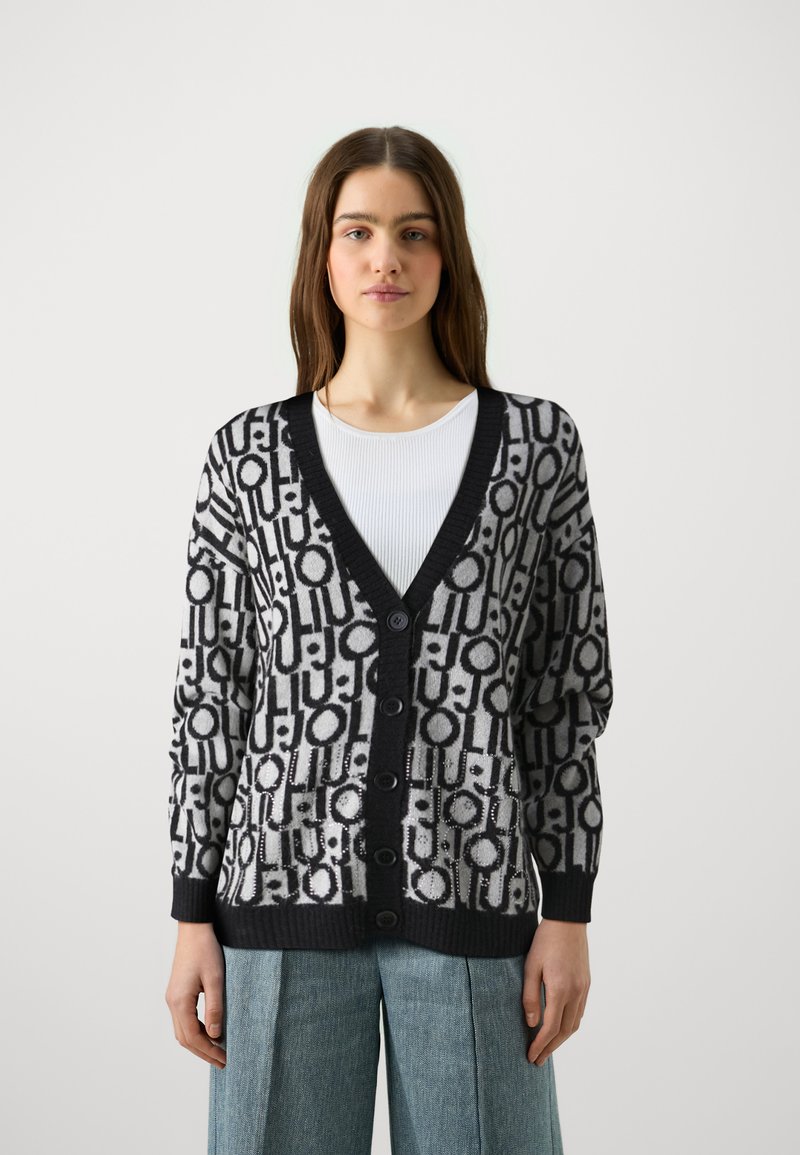 Cardigan lavorato a maglia con un motivo geometrico bianco e nero, maniche lunghe, scollatura a V profonda e bottoni frontali. Polsini e orlo a coste.
