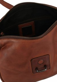 Braune Leder-Umhängetasche mit Reißverschluss, Innenfach und einem kleinen Metallakzent. Die Oberfläche ist glatt mit einem leichten Glanz.