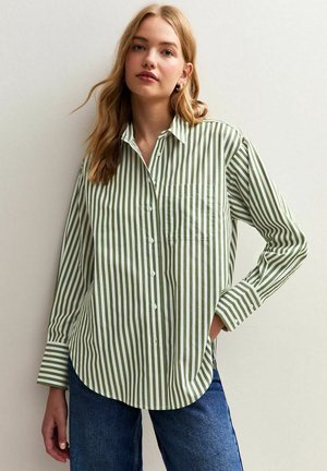 Groen en wit gestreepte overhemden met een klassieke kraag, lange mouwen en een borstzak, gecombineerd met casual blauwe jeans.