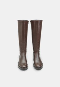 Botas de cuero marrón hasta la rodilla con textura suave, puntera redonda y cremalleras en los laterales. Suelas planas que ofrecen estabilidad y comodidad al usarlas.