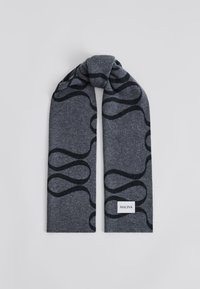 Szary dzianinowy szalik z czarnym, wirowym wzorem. Wykończony małą białą metką z napisem "MALINA" na dole. Miękka tekstura.