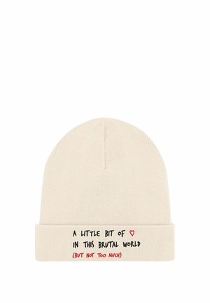 Bonnet en tricot beige avec un revers plié. Présente un texte noir et un graphique de cœur rouge disant : « Un peu de ceci dans ce monde brutal (mais pas trop). »