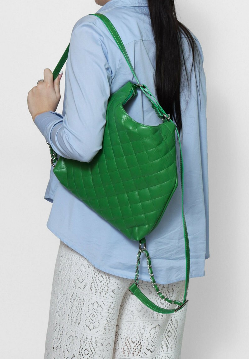 Borsa a tracolla in pelle verde trapuntata con una forma arrotondata e spaziosa. Presenta una tracolla lunga e una piccola tracolla con catena attaccata.