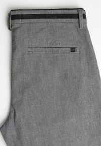 Szare spodnie z tkaniny o wąskim kroju. Posiadają czarny pas w talii oraz tylną kieszeń z logo. Prosty i fakturowany wzór.