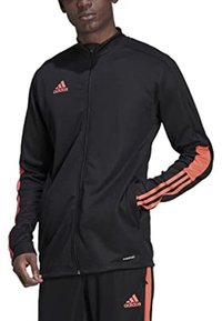 Giacca felpa nera con zip della Adidas, dotata di logo arancione e tre strisce sulle maniche. Realizzata in tessuto morbido e leggero.