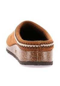 Scarpa marrone slip-on con una tomaia morbida, collo testurizzato e intersuola in sughero maculato. Presenta una suola in gomma per la presa e la stabilità.