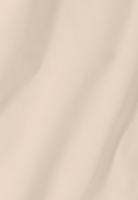 Tissu beige avec des plis doux et une texture lisse, présentant des ombres subtiles et des variations de lumière sur toute la surface.