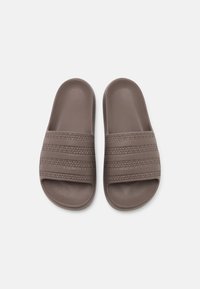 Claquettes en caoutchouc marron avec trois bandes horizontales texturées et une surface lisse. Bout et talon arrondis, design profil bas.