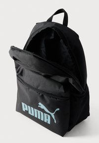 Μαύρο υφασμάτινο σακίδιο με μεγάλη μπροστινή τσέπη, κλείσιμο με φερμουάρ και μπλε λογότυπο Puma. Διαθέτει υφή επιφάνειας και διχτυωτή πλαϊνή τσέπη.