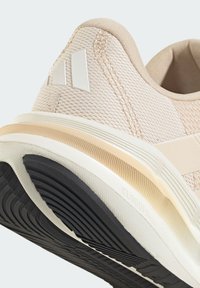 Baskets en maille beige avec un dessus texturé, des accents blancs et une semelle multicouche multicolore dotée d'une semelle en caoutchouc noir.