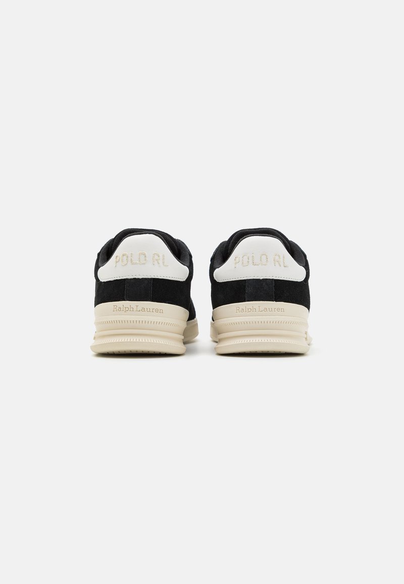 Schwarze Wildleder-Sneaker mit weißen Fersenakzenten. Mit "POLO RL" Branding in Gold auf der Rückseite und einer leichten beigen Sohle.