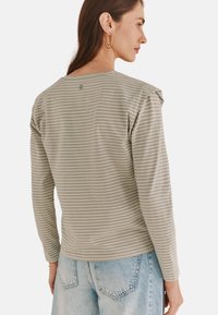 Lys grøn langærmet skjorte med hvide vandrette striber, der har en rund halsudskæring og let plisseringer ved skulderen. Casual fit.
